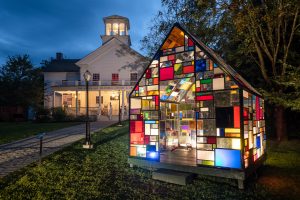Nighttime image of a building made of stained glass and lit from inside